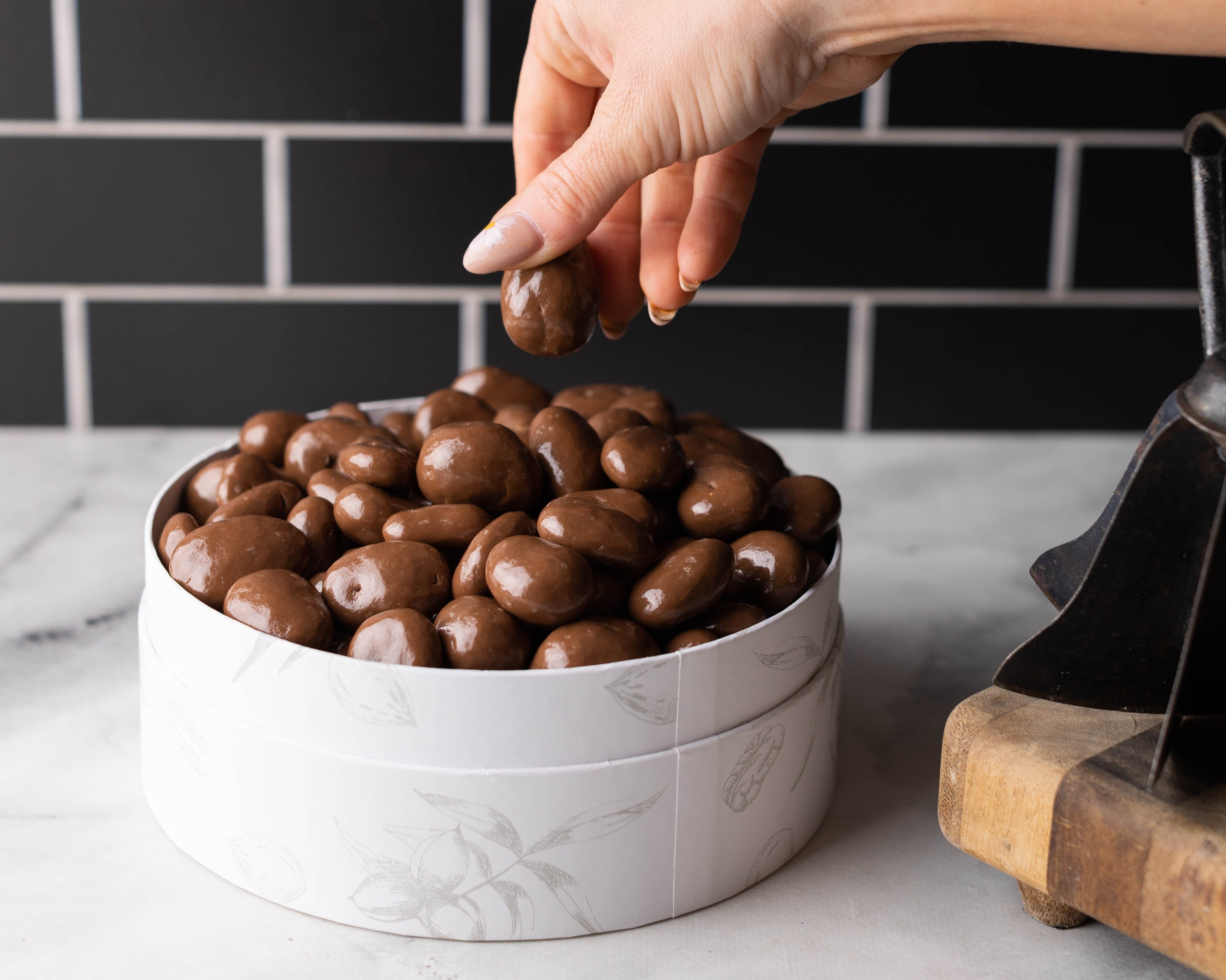 Hand Grabbing Chocolate Pecans